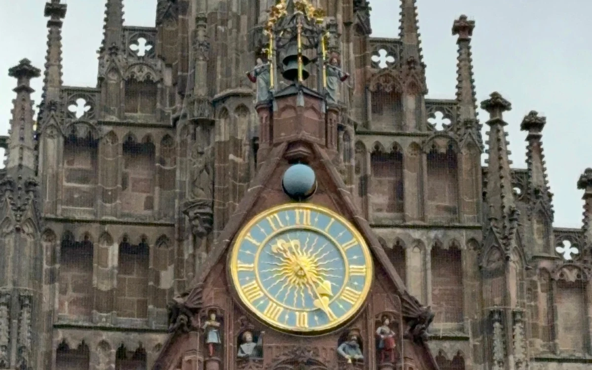 Ein geschnitzter gotischer Kirchengiebel mit goldener Uhr in Nürnberg
