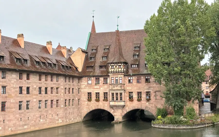 Ein mittelalterliches Spitalgebäude auf Steinbögen über dem Fluss in Nuremberg