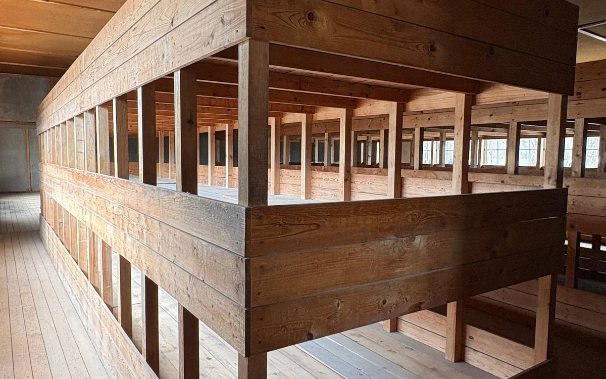 Lettere a castello in legno all'interno di una baracca, lungo un pavimento di assi spoglie